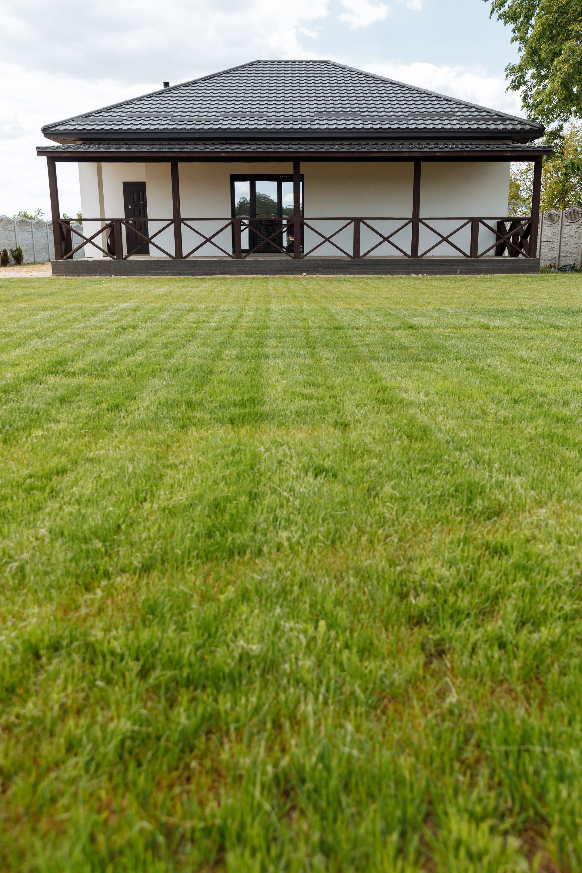 A modern house with a large freshly mowed lawn ideal for real estate or gardening themes.
